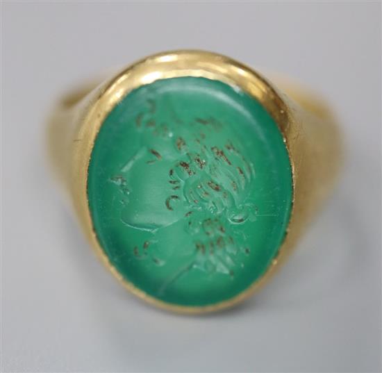 An early 20th century 18ct gold, and intaglio chrysophase? oval ring, carved with the head of a lady to dexter, size J, gross 5.6